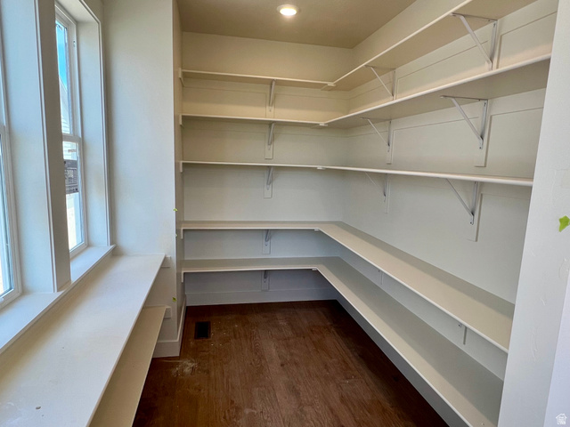 11507 Markfield Way, Unit 1124 South Jordan, UT 84009 - Photo 5 of 6 Walk-in pantry featuring extensive white shelving, multiple windows, recessed ceiling lighting, and wood-finish flooring