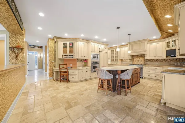 a kitchen with stainless steel appliances kitchen island granite top and refrigerator