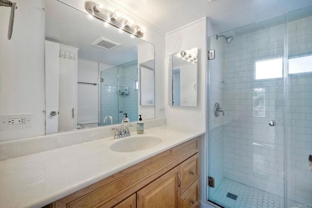 a bathroom with a shower sink vanity and mirror