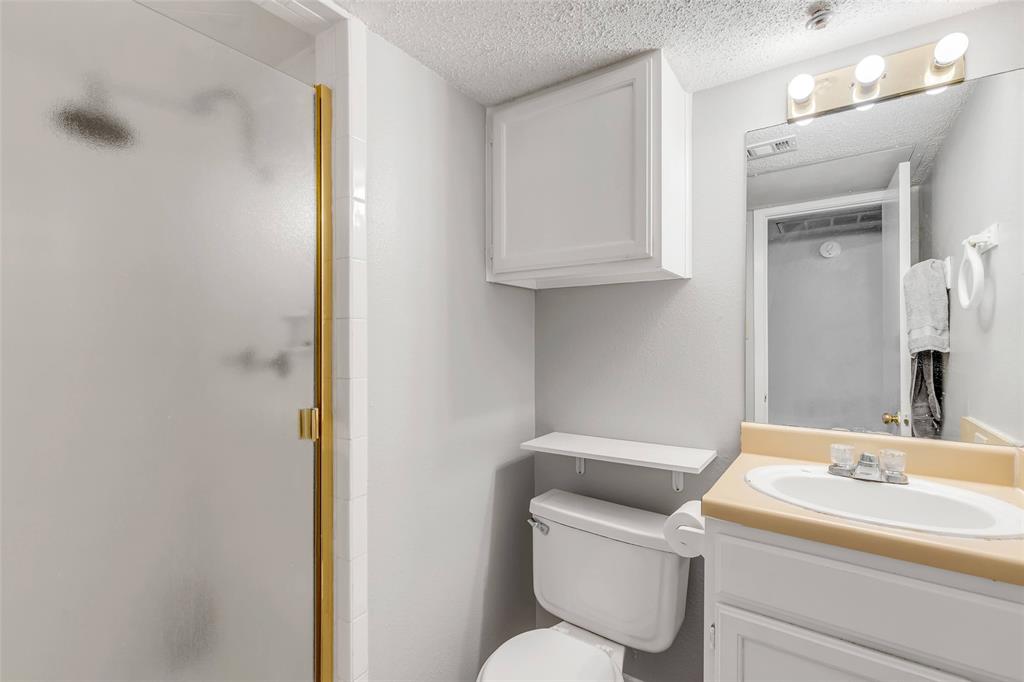 3115 Helms Street, Unit 210 Austin, TX 78705 - Photo 11 of 17 a bathroom with a toilet sink and mirror