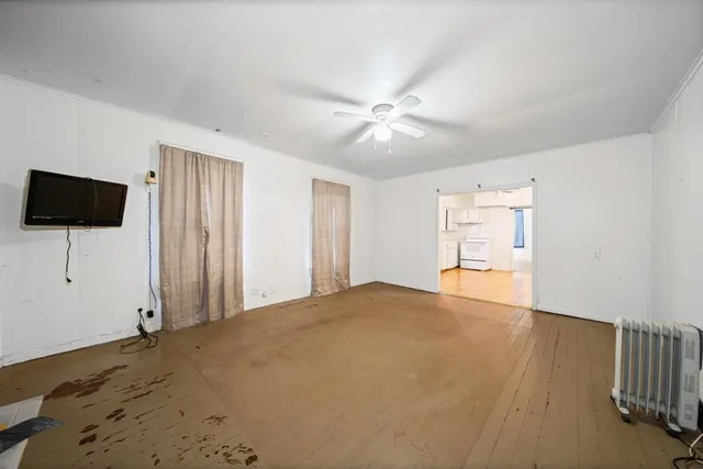 a view of a livingroom with wooden floor and a flat screen tv