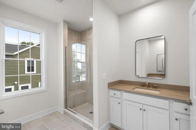 a bathroom with a shower sink and mirror