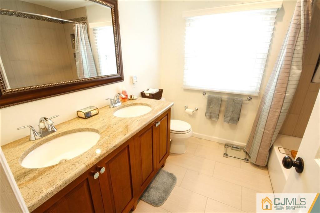 32 Summerall Road Somerset, NJ 08873 - Photo 14 of 17 a bathroom with a granite countertop sink a mirror and a shower