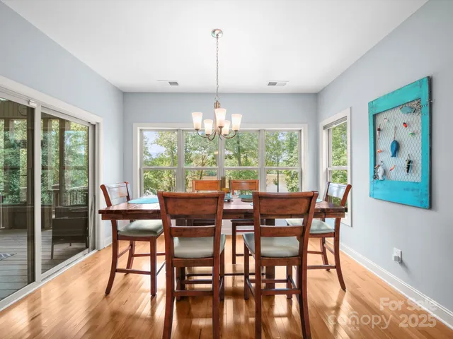 a dining room with furniture a chandelier and wooden floor