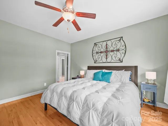 a bedroom with a bed and a flat tv screen on dresser