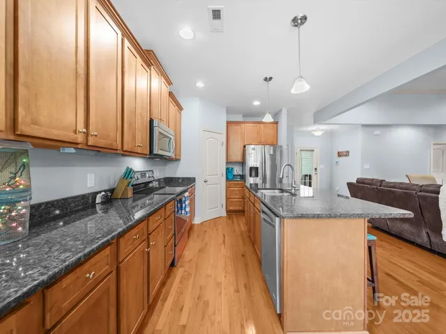 a large kitchen with stainless steel appliances granite countertop a stove a sink and a granite counter tops