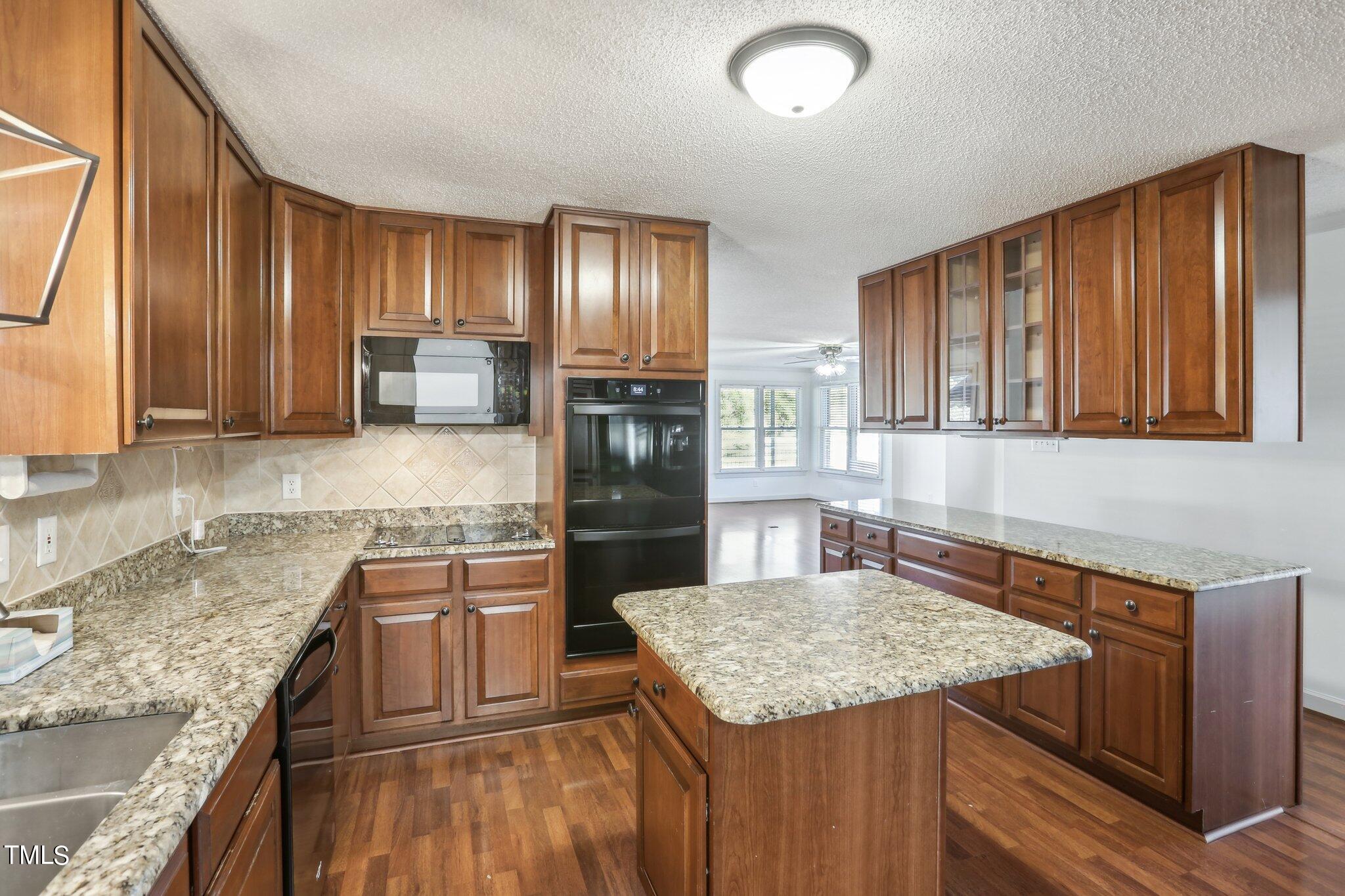 1517 Crickett Road Raleigh, NC 27610 - Photo 11 of 41 a kitchen with stainless steel appliances granite countertop wooden cabinets and a counter top space