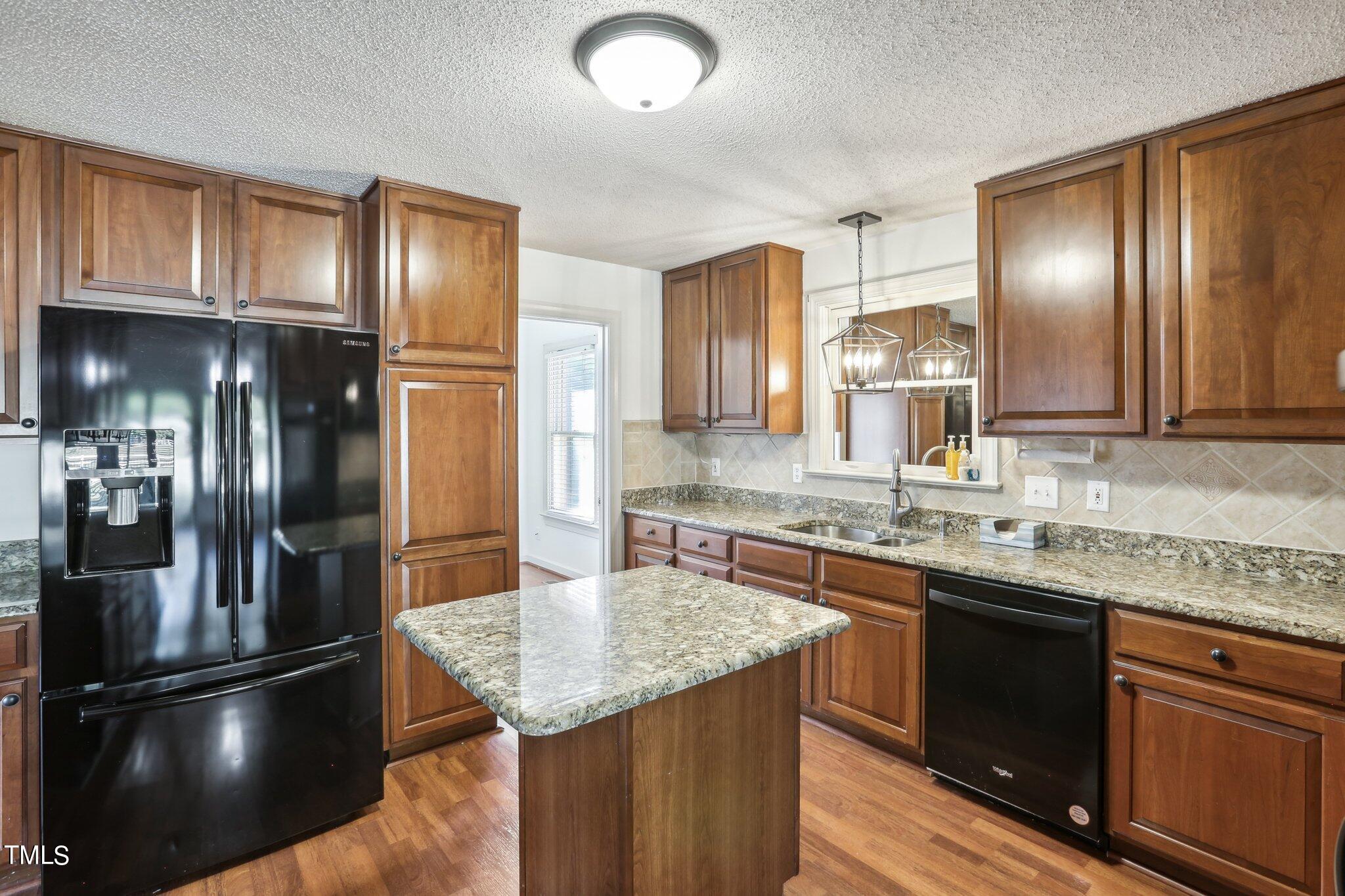 1517 Crickett Road Raleigh, NC 27610 - Photo 12 of 41 a kitchen with stainless steel appliances granite countertop a refrigerator a sink and wooden cabinets