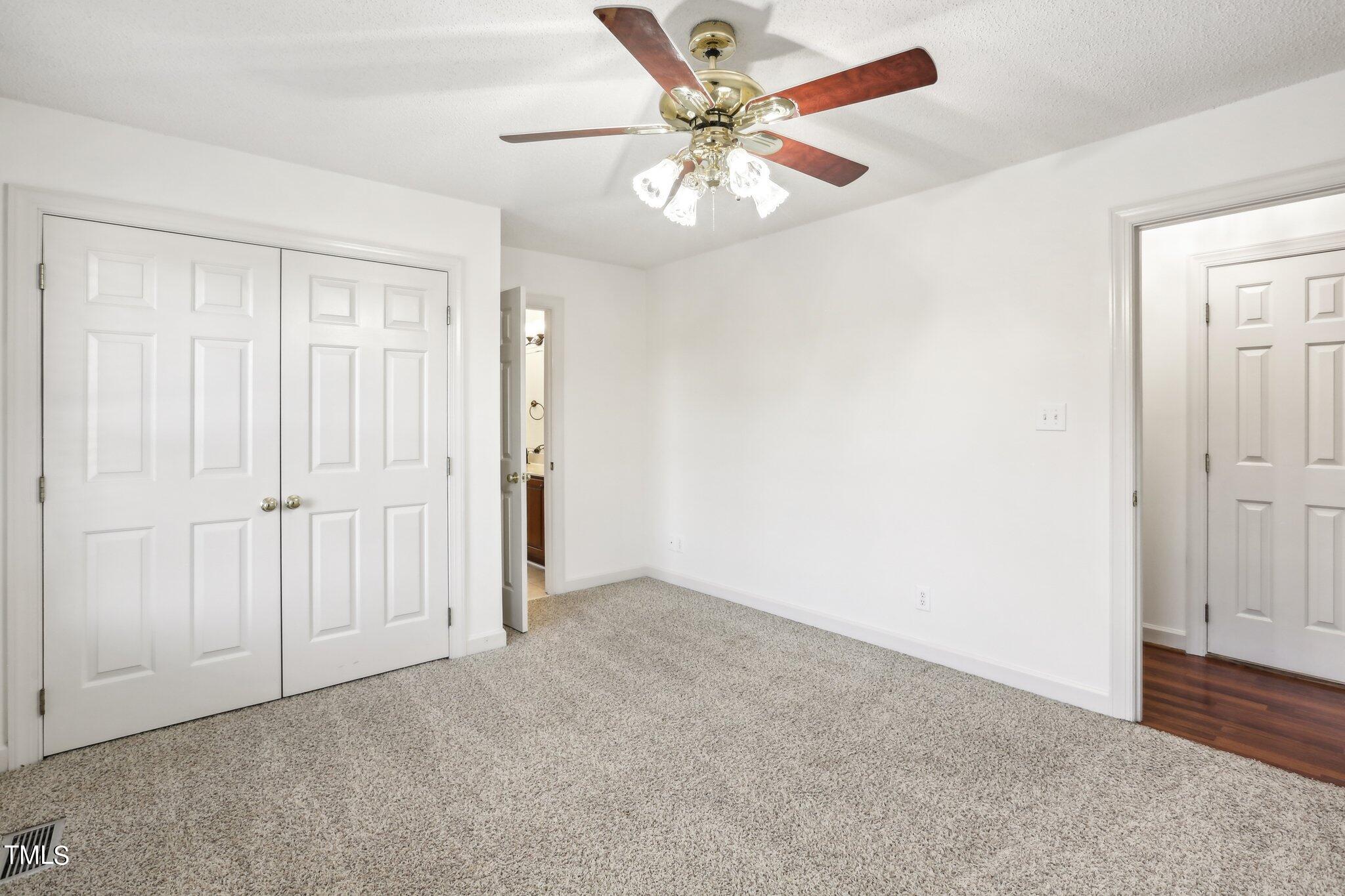 1517 Crickett Road Raleigh, NC 27610 - Photo 16 of 41 an empty room with a chandelier fan and closet area