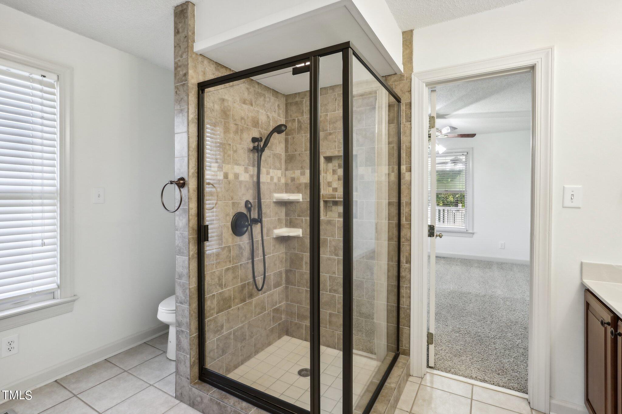 1517 Crickett Road Raleigh, NC 27610 - Photo 19 of 41 a bathroom with a glass shower door and a mirror