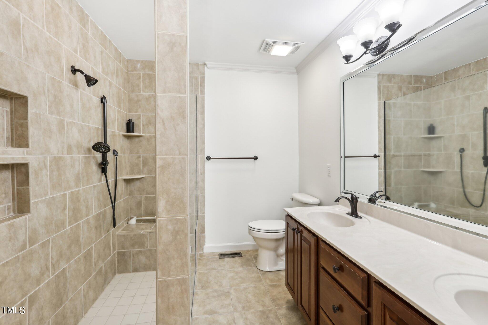 1517 Crickett Road Raleigh, NC 27610 - Photo 26 of 41 a bathroom with a double vanity sink toilet and shower