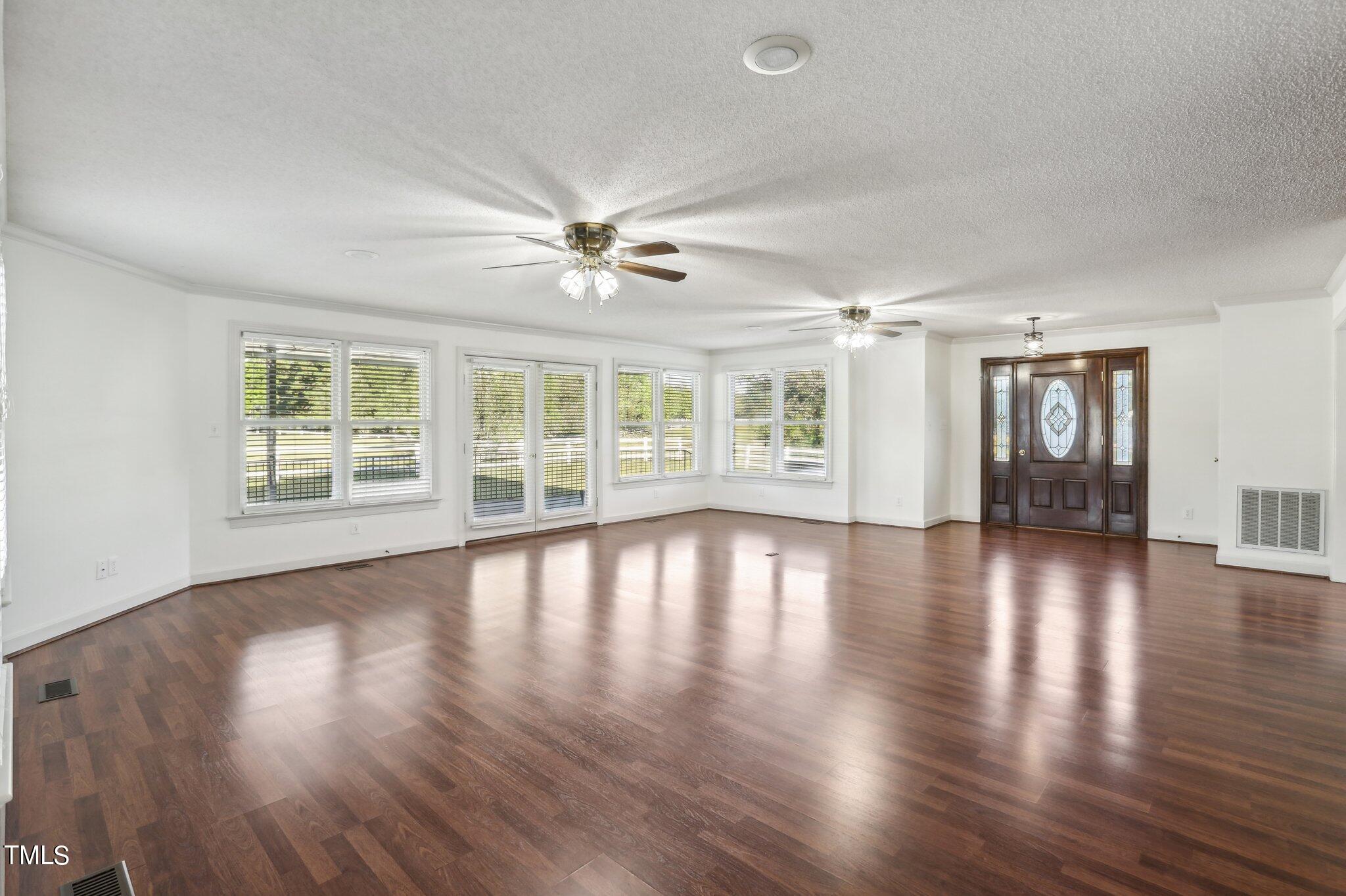 1517 Crickett Road Raleigh, NC 27610 - Photo 7 of 41 a view of an empty room with wooden floor and a window