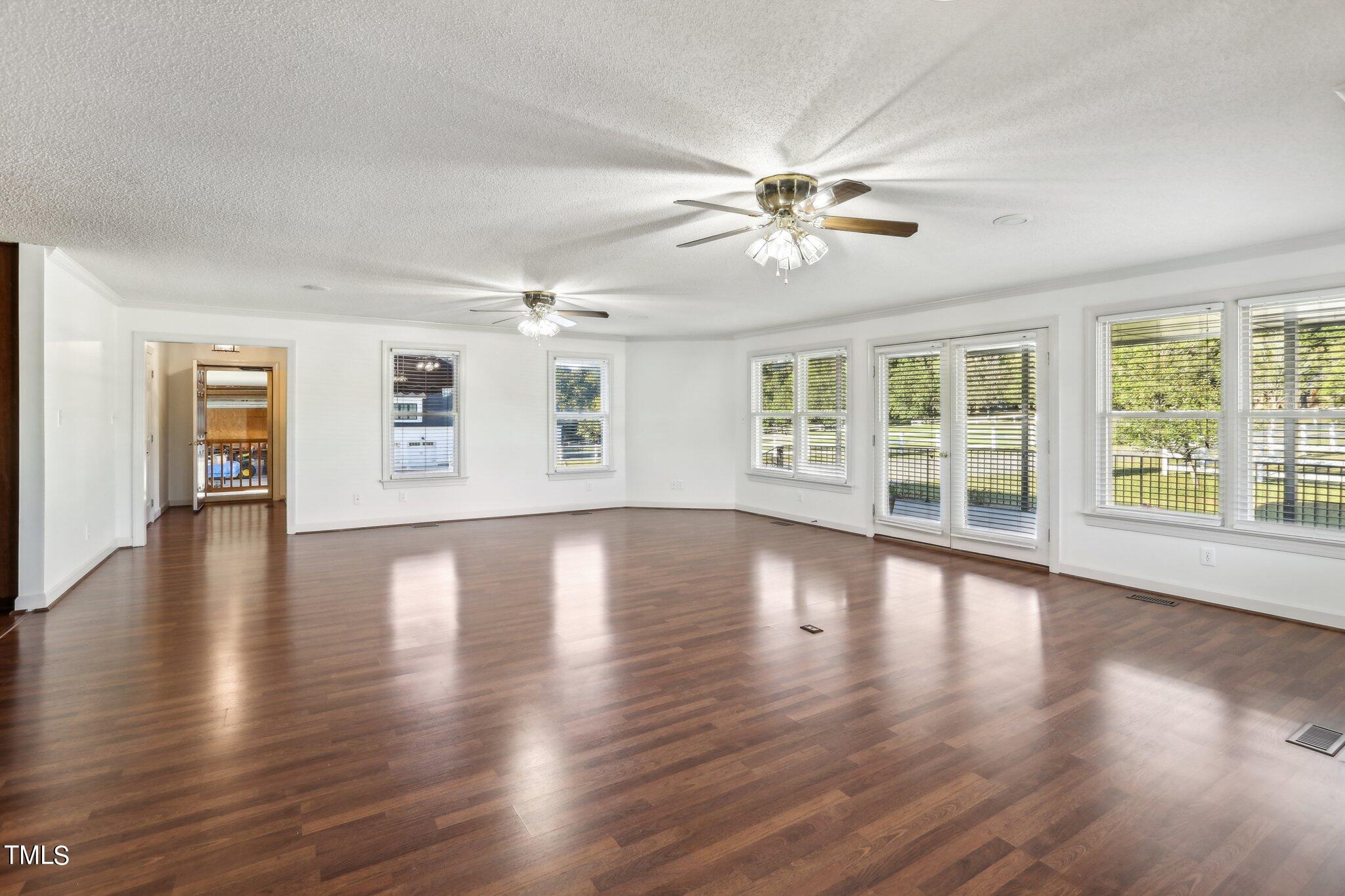 1517 Crickett Road Raleigh, NC 27610 - Photo 8 of 41 a view of an empty room with wooden floor and a window