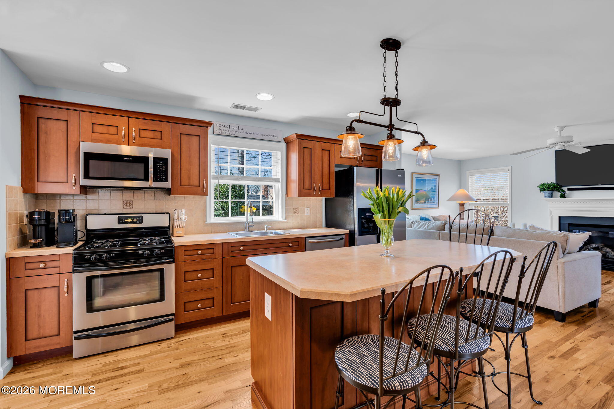 2404 Chestnut Street Point Pleasant, NJ 08742 - Photo 6 of 16 a kitchen with stainless steel appliances kitchen island granite countertop a stove a refrigerator a kitchen island a dining table and chairs with wooden floor