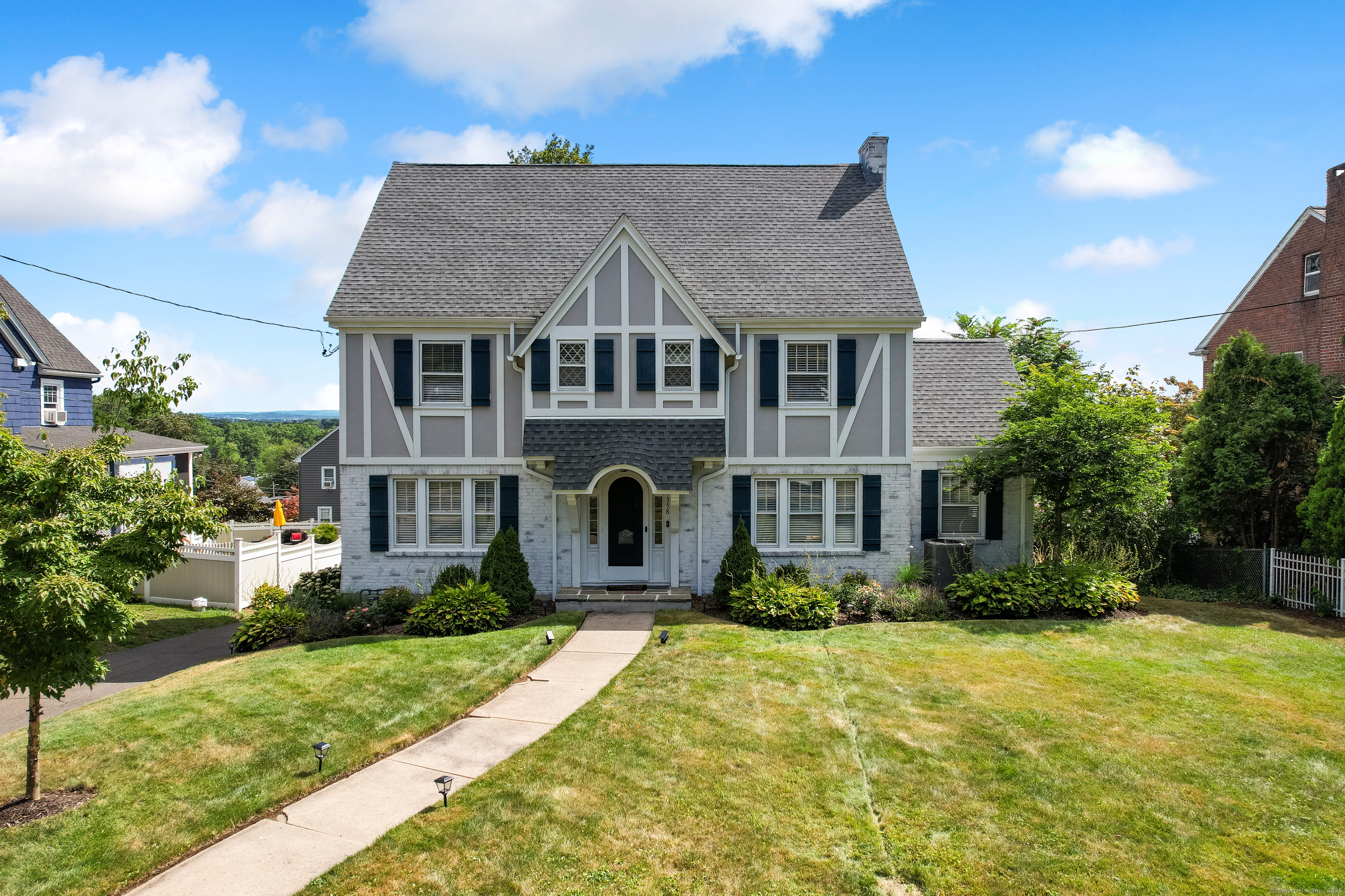 a front view of a house with yard and green space