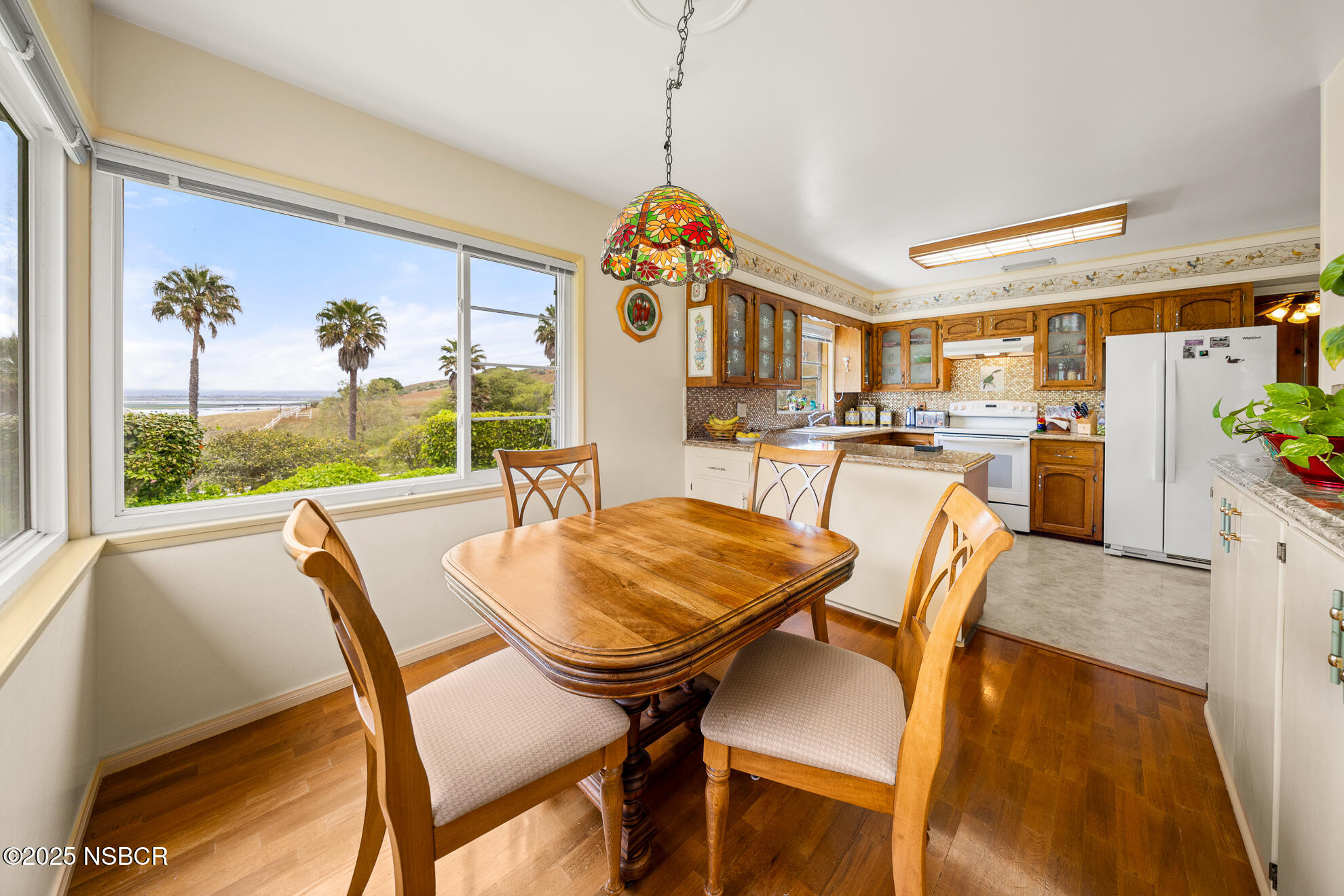 4314 West Ocean Avenue Lompoc, CA 93436 - Photo 19 of 58 a dining room with furniture a chandelier and wooden floor