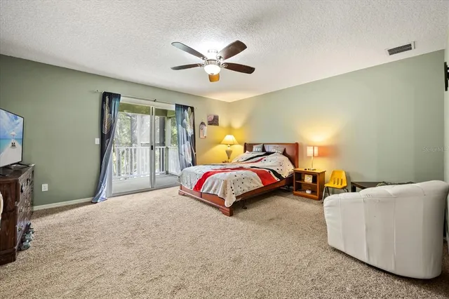 a bedroom with two beds and ceiling fan