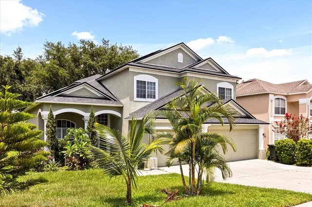 a view of a white house with a small yard and plants