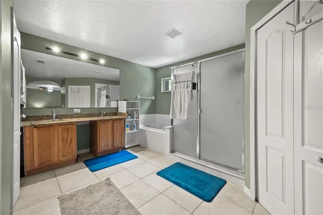 a large bathroom with a glass door shower a sink and a mirror