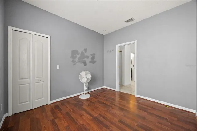 a view of empty room with wooden floor