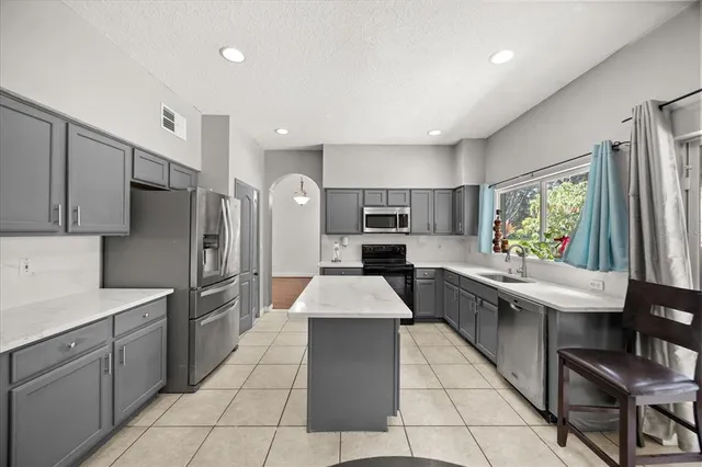 a kitchen with stainless steel appliances granite countertop a sink and a refrigerator