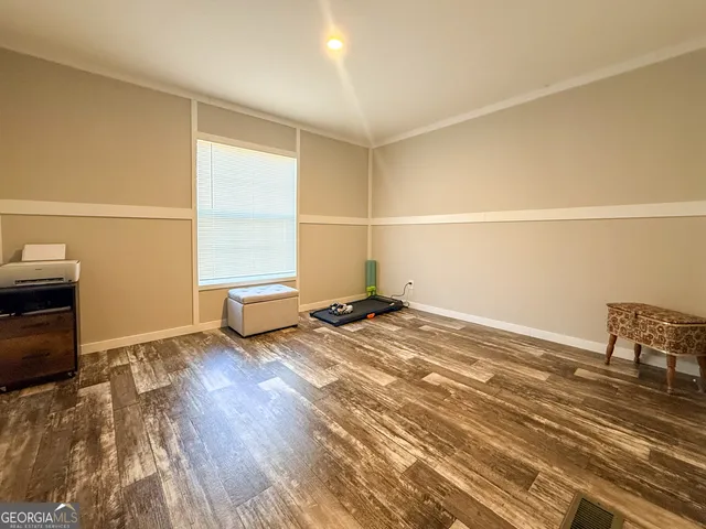 a view of a room with wooden floor and lounge chair
