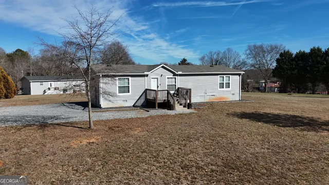 a view of a house with backyard and trees