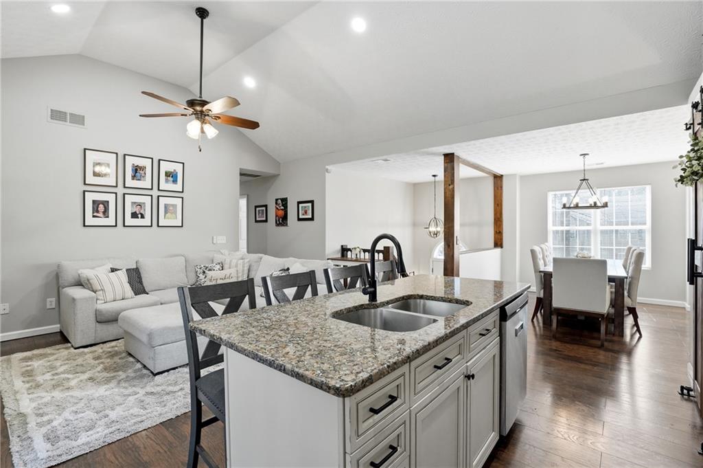 378 Baugh Street Commerce, GA 30529 - Photo 12 of 35 a kitchen with granite countertop a sink a counter top space and living room