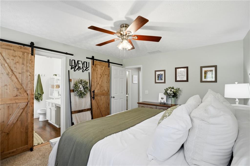 378 Baugh Street Commerce, GA 30529 - Photo 16 of 35 a bedroom with a bed and a chandelier