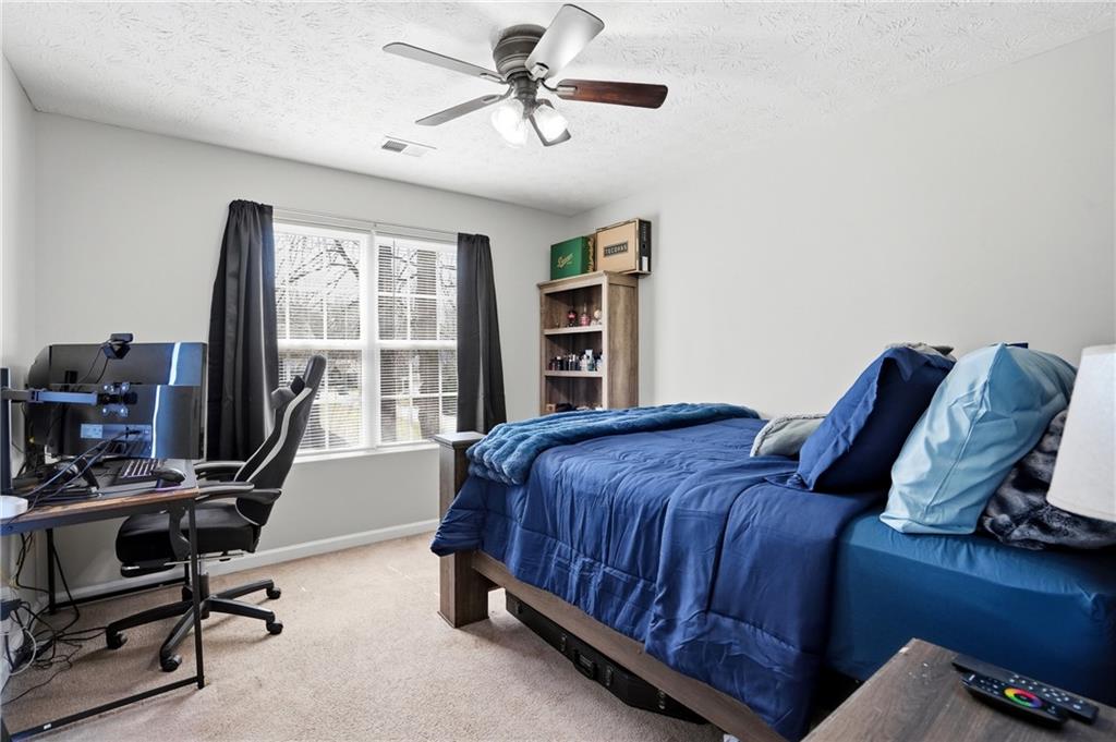 378 Baugh Street Commerce, GA 30529 - Photo 24 of 35 a bedroom with a bed a desk and chair with a bookshelf