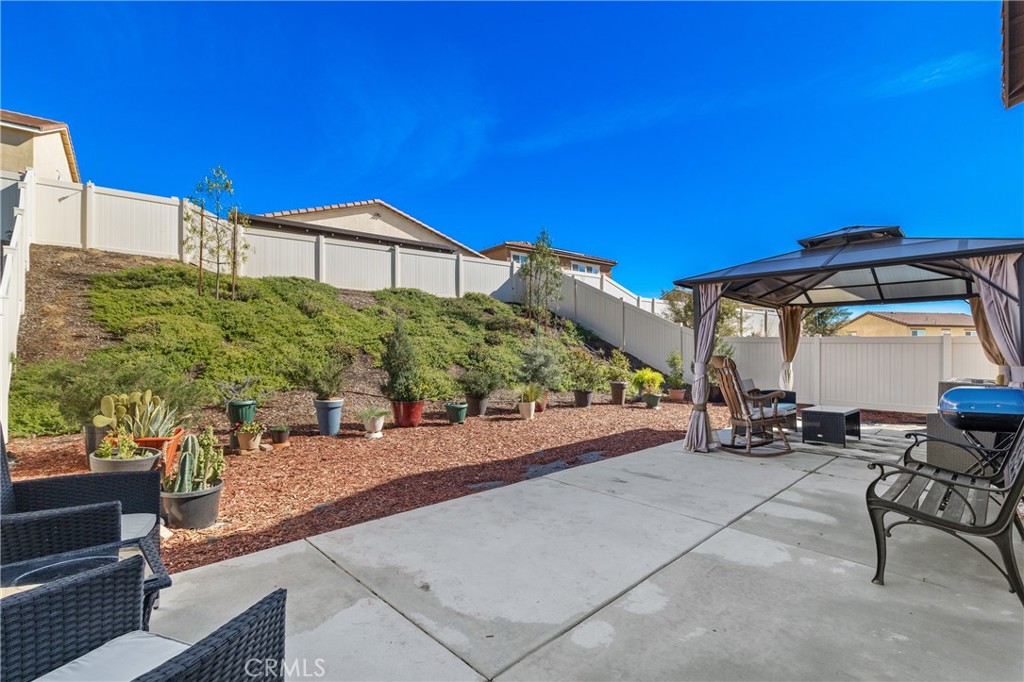 11738 Murray Way Beaumont, CA 92223 - Photo 31 of 45 a view of a patio with a table and chairs under an umbrella