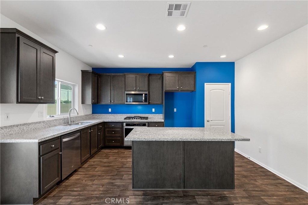 11738 Murray Way Beaumont, CA 92223 - Photo 6 of 45 a large kitchen with stainless steel appliances granite countertop a large counter top a sink and a stove