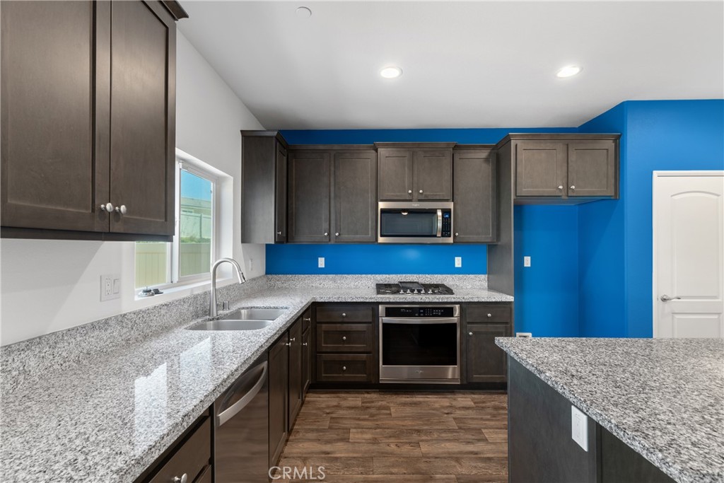 11738 Murray Way Beaumont, CA 92223 - Photo 7 of 45 a kitchen with kitchen island granite countertop wooden cabinets and a sink