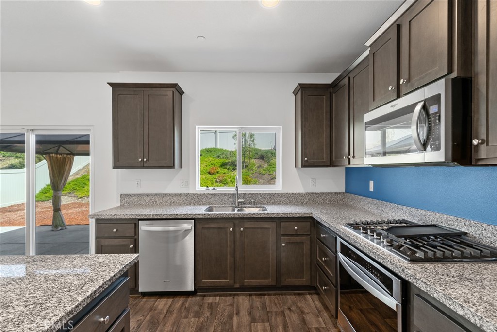 11738 Murray Way Beaumont, CA 92223 - Photo 8 of 45 a kitchen with stainless steel appliances granite countertop a stove a sink and a microwave