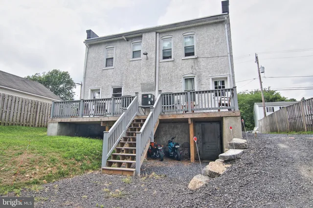 a view of a chairs and table on deck with wooden floor and fence