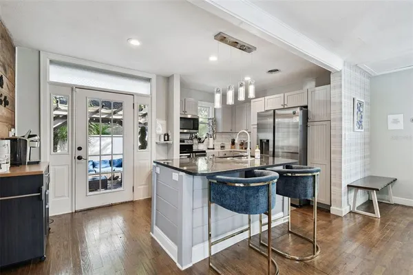 a kitchen with stainless steel appliances granite countertop a sink a refrigerator and a refrigerator