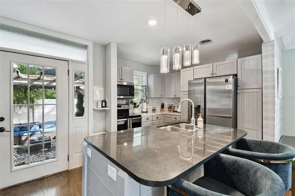 a kitchen with a refrigerator and a stove top oven
