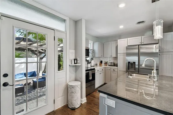 a kitchen with stainless steel appliances granite countertop a sink dishwasher stove and refrigerator
