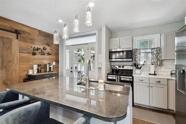 a kitchen with stainless steel appliances granite countertop a sink stove and refrigerator