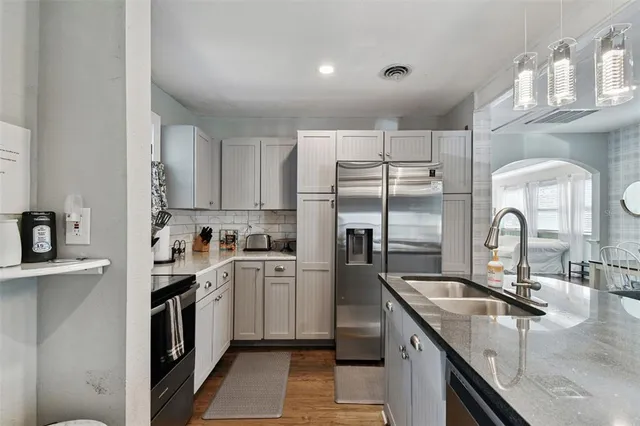 a kitchen with stainless steel appliances granite countertop a sink and a refrigerator