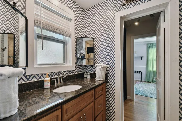 a bathroom with a granite countertop sink and a mirror