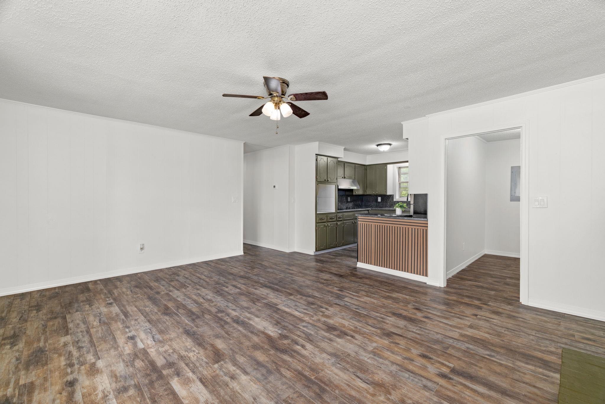 217 Red Bay Road Golden, MS 38847 - Photo 7 of 33 Spacious open-concept living area featuring wood-finish flooring, a ceiling fan, and white walls