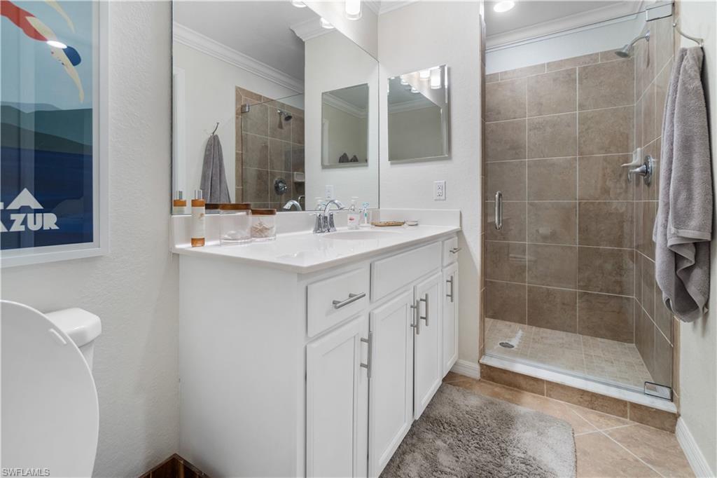 9834 Giaveno Circle, Unit 1726 Naples, FL 34113 - Photo 14 of 20 a bathroom with a double vanity sink mirror and shower