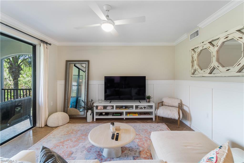 9834 Giaveno Circle, Unit 1726 Naples, FL 34113 - Photo 2 of 20 a living room with furniture and a flat screen tv