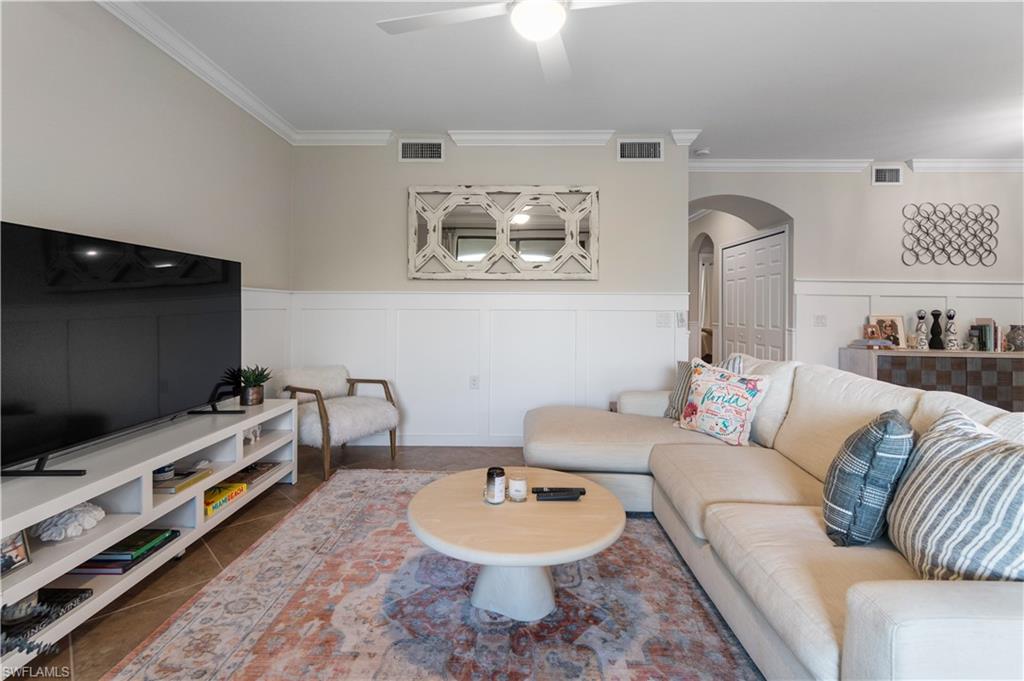 9834 Giaveno Circle, Unit 1726 Naples, FL 34113 - Photo 3 of 20 a living room with furniture and a flat screen tv