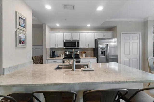 a kitchen with refrigerator and chairs