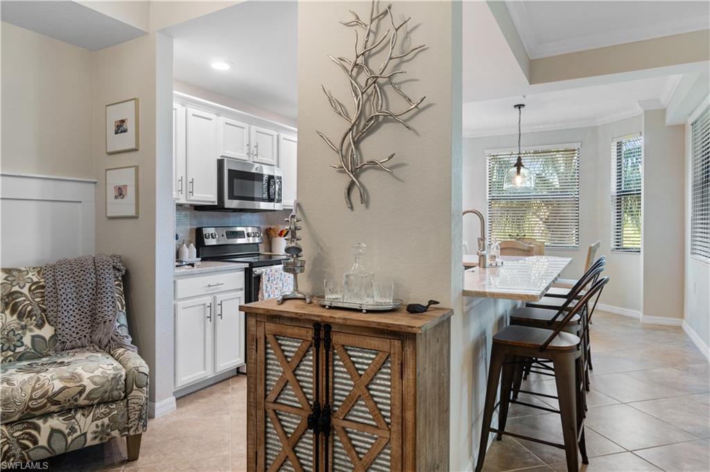 9834 Giaveno Circle, Unit 1726 Naples, FL 34113 - Photo 9 of 20 a living room with furniture and a flat screen tv