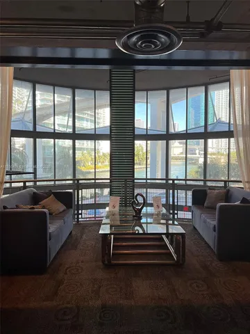 a living room with furniture and floor to ceiling windows