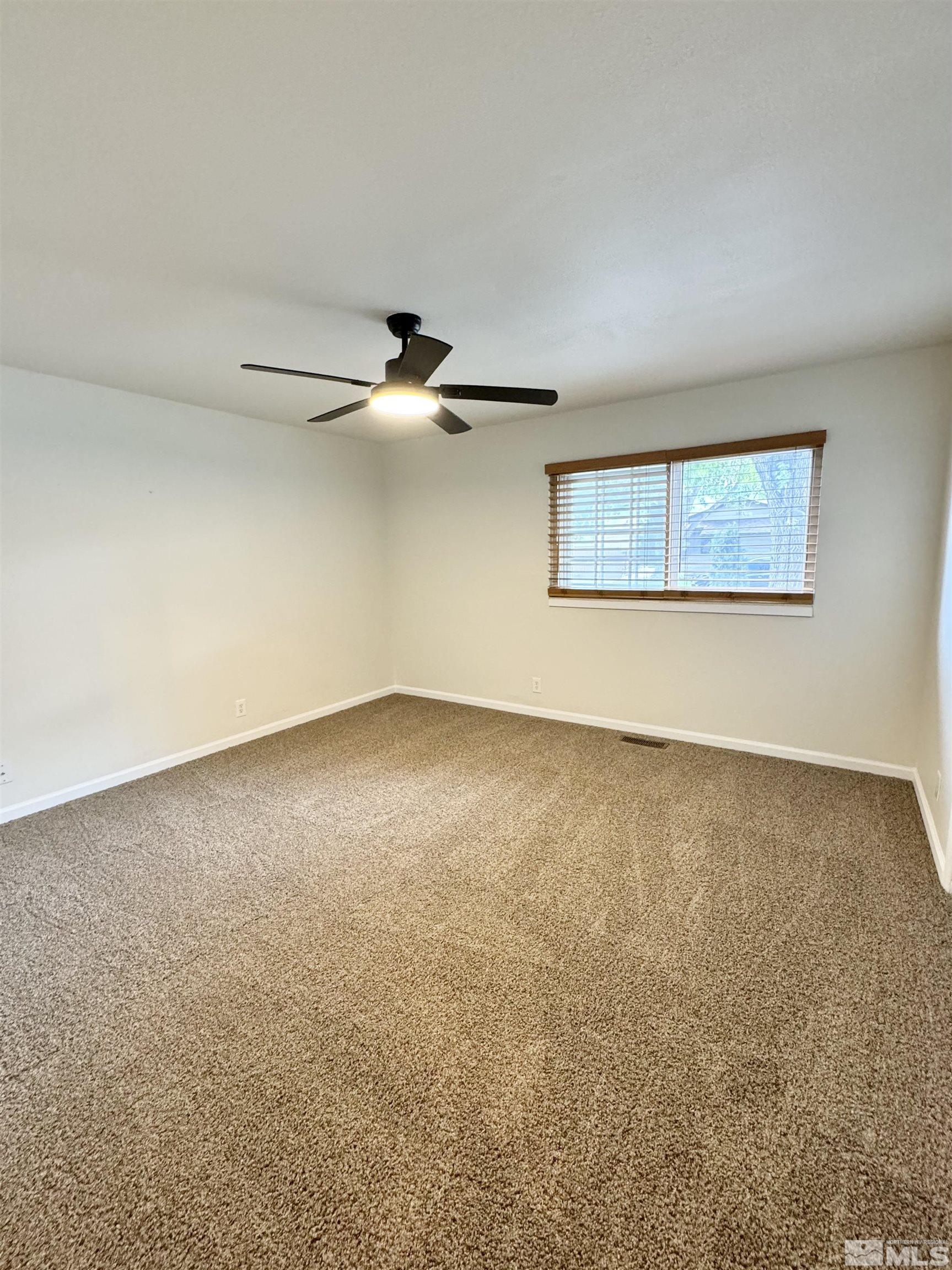 4640 Aster Drive Reno, NV 89502 - Photo 19 of 22 an empty room with a ceiling fan and window
