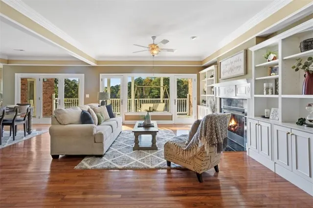 a living room with furniture floor to ceiling window and wooden floor